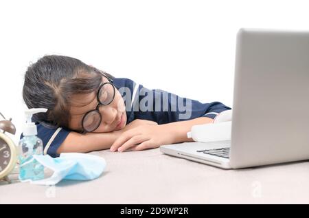 L'étudiant s'est endormi pendant ses devoirs avec le PC portable isolé sur fond blanc, concept éducatif Banque D'Images