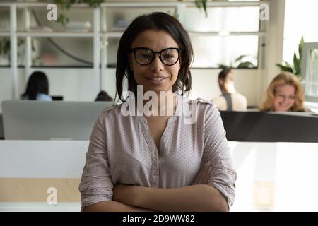 Femme cadre biraciale confiante regardant l'appareil photo avec un sourire heureux Banque D'Images