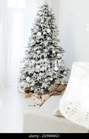 Sapin de Noël blanc enneigé avec décoration de cadeaux à l'intérieur de la carte postale de la maison du nouvel an Banque D'Images