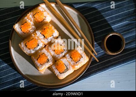 Des petits pains au saumon et au caviar sont servis sur un fond de bois blanc. Lumière du matin Banque D'Images