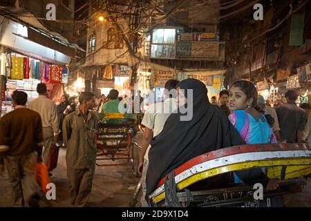 Delhi, Inde, janvier 2008. Deux femmes en pousse-pousse dans une rue surpeuplée de la vieille ville de Delhi la nuit. Banque D'Images