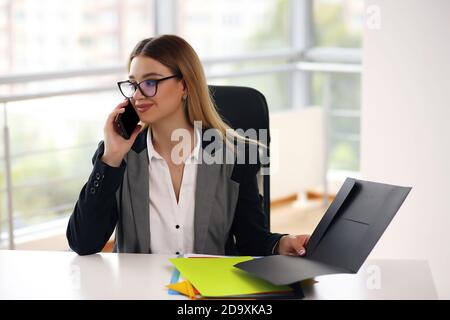 Jeune femme d'affaires souriante et heureuse travaillant au bureau Banque D'Images