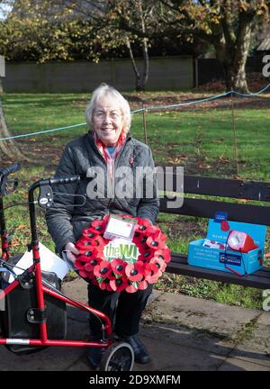 Biggin Hill, Royaume-Uni, 8 novembre 2020, malgré le confinement, les gens assistent à un service de souvenir à Biggin Hill Kent. Une dame représentant l'Institut des femmes assis sur un banc de vente de coquelicots avant de poser sa couronne.Credit: Keith Larby/Alamy Live News Banque D'Images