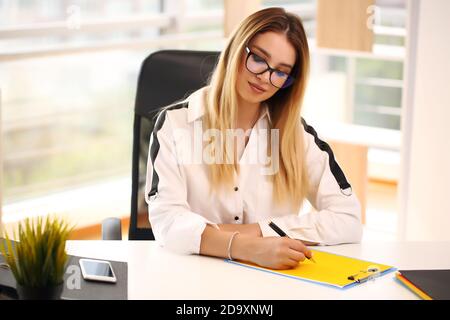 Une femme d'affaires rêveuse et détendue, qui a réussi à se reposer sur son lieu de travail Banque D'Images