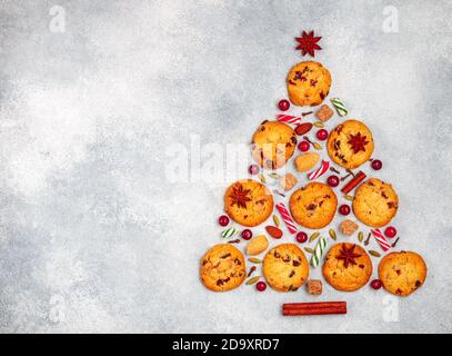 Fond culinaire de biscuits aux canneberges, au chocolat blanc, aux amandes et aux épices sous forme d'arbre de Noël. Composition de biscuits, cinnamo Banque D'Images