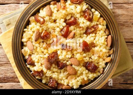 Mesfouf couscous algérien doux aux noix et raisins secs dans une assiette sur la table. Vue verticale du dessus Banque D'Images