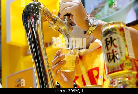 (201108) -- SHANGHAI, le 8 novembre 2020 (Xinhua) -- UN membre du personnel sert de la bière au stand de la brasserie Kirin à l'aire d'exposition produits alimentaires et agricoles lors de la troisième China International Import Expo (CIIE) à Shanghai, en Chine orientale, le 7 novembre 2020. (Xinhua/Fang Zhe) Banque D'Images