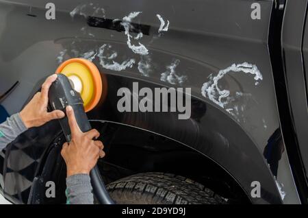 L'homme travaillant pour le polissage, de revêtements automobiles. le polissage de la voiture vous aidera à éliminer les contaminants sur la surface de la voiture.cirer la location de surface sera c Banque D'Images