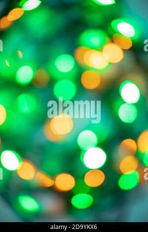 arrière-plan bokeh abstrait de lumières festives du soir dans des lumières rondes vertes, jaunes et orange. Concept de Noël Banque D'Images