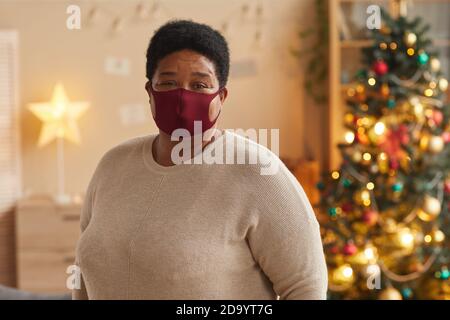 Portrait à la taille haute de femme afro-américaine senior portant un masque et regardant l'appareil photo tout en célébrant Noël, espace copie Banque D'Images