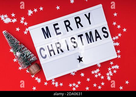 Merry Christmas Flat Lay avec texte sur la visionneuse et petit Arbre de Noël Banque D'Images