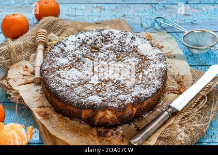 Gâteau épicé à l'orange et aux amandes, saupoudré de sucre glace et arrosé de miel Banque D'Images