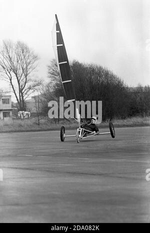 Années 1980, historique, un concurrent masculin participant à une compétition de char à voile, Angleterre, Royaume-Uni. Également connue sous le nom de voile terrestre, l'activité implique un véhicule à roues alimenté par le vent grâce à l'utilisation d'une voile. Banque D'Images