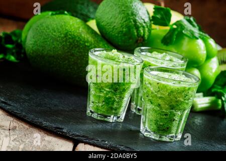 Smoothie détox vert frais à base de pommes, d'avocats, de légumes verts, de citron vert et de céleri sur fond sombre, mise au point sélective Banque D'Images