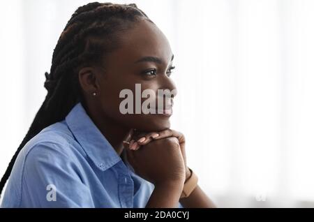 Planifier l'avenir. Vue latérale Portrait de la jeune femme afro-américaine pensive rêvant de jour Banque D'Images