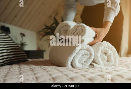 Un service de chambre. Changement des serviettes femme dans chambre d'hôtel. Banque D'Images