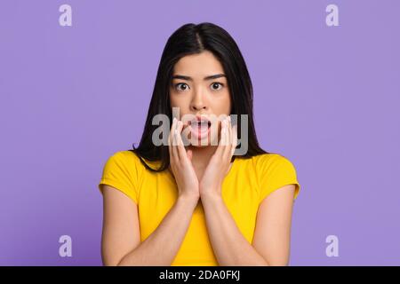 Gros plan Portrait d'une femme asiatique choquée touchant le visage et ouvrant Bouche Banque D'Images