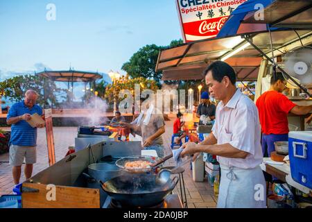 Dîner en plein air sur une place parmi les fourgonnettes de restauration roulotte à Papeete sur l'île de Tahiti, Tahiti Nui, Society Islands, Polynésie française, Pacifique Sud. Banque D'Images