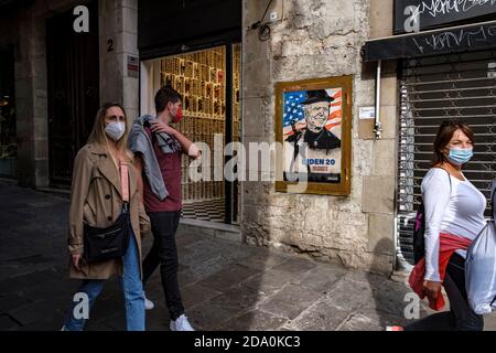 Barcelone, Catalogne, Espagne. 8 novembre 2020. Les gens qui marchent devant le nouveau graffiti.Street graffiti artiste tvBoy a fait un nouveau morceau à la Plaza Sant Jaume pour célébrer la victoire de Joe Biden aux élections américaines. Crédit : Paco Freire/SOPA Images/ZUMA Wire/Alay Live News Banque D'Images