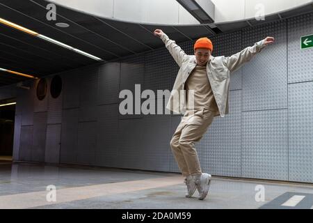 Tout le corps de jeunes Afro-américaines positives avec des cheveux bouclés dans des vêtements décontractés souriant tout en laissant un café moderne avec des tasses à café à emporter et Banque D'Images