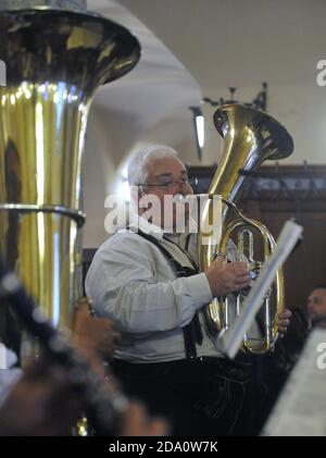 Un joueur de tuba habillé à Lederhosen dans un groupe traditionnel de cuivres bavarois joue dans le célèbre pub Hofbrahaus de Munich, en Allemagne. Banque D'Images