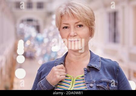Portrait d'une femme mûre attrayante aux cheveux blonds qui marche à l'intérieur du centre commercial. Banque D'Images