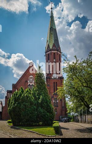 Belle église en brique rouge avec une tour d'horloge, une paroisse évangélique d'Augsbourg. Église de la Sainte Trinité à Szczecin, Pologne Banque D'Images