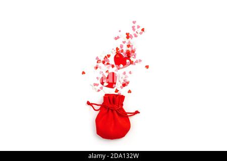 Sac cadeau rouge et coeurs de différentes formes et couleurs sur fond clair. Banque D'Images