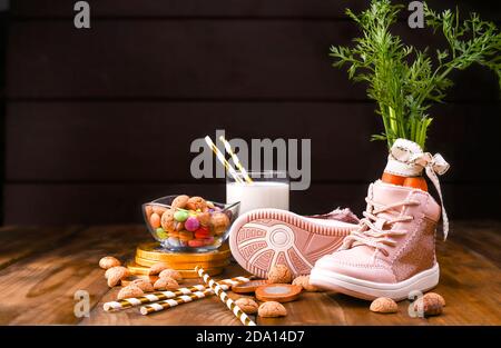 Arrière-plan en bois avec chaussures pour enfants avec carottes pour le cheval du Père Noël, pepernoten et sucreries. Carte postale traditionnelle néerlandaise de vacances Sinterklaas . Vue de dessus. Copier l'espace. Photo de haute qualité. Banque D'Images