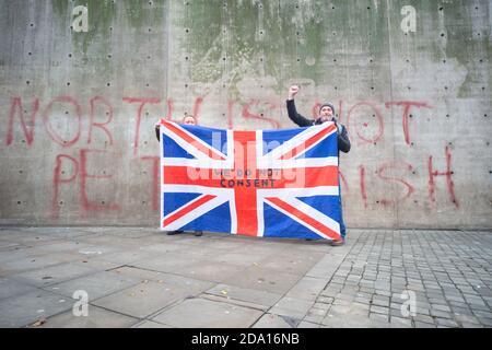 Manchester 08-11-2020, deux hommes détiennent un drapeau syndical devant le mur « le Nord n'est pas un pétri » lors de la manifestation anti-verrouillage du 8 novembre 2020 Banque D'Images