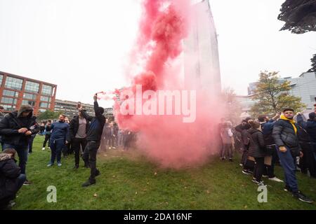 Manchester 08-11-2020, un homme laisse échapper une fumée rouge dans Piccadilly Gardens tout en diffusant l'événement. Manifestations anti-verrouillage Banque D'Images