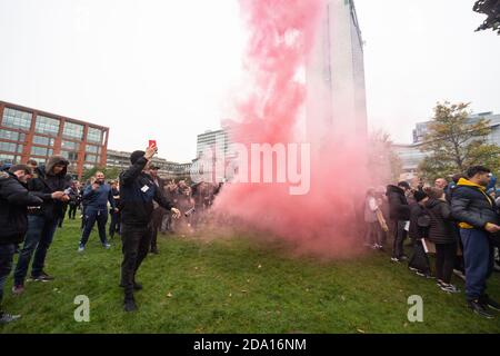 Manchester 08-11-2020, un homme laisse échapper une fumée rouge dans Piccadilly Gardens tout en diffusant l'événement. Manifestations anti-verrouillage Banque D'Images