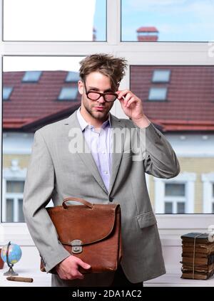 Concept d'éducation et de travail. Professeur ou travailleur sérieux avec des soies dans des verres de nerd. Homme avec porte-documents isolé sur fond blanc. Nerd ou bookworm portant une veste classique. Banque D'Images