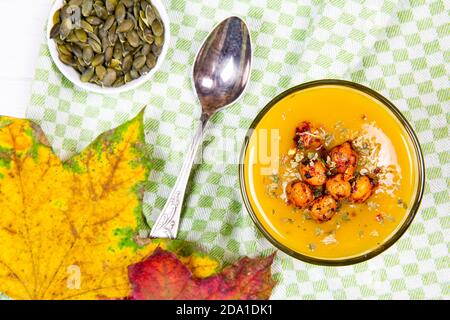 Délicieuse soupe de potiron, vue de dessus. Fête de Thanksgiving délicieux hors-d'œuvre, graines et petite décoration de citrouilles. Banque D'Images