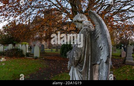 Statue d'ange bourrée de pierre dans un cimetière, église paroissiale de St Mary au crépuscule, Haddington, East Lothian, Écosse, Royaume-Uni Banque D'Images