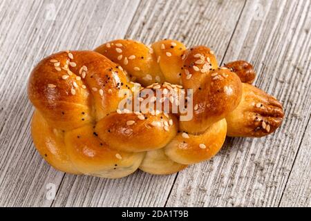 Pain blanc tressé fait maison de type Europe de l'est isolé sur une table en bois. Banque D'Images