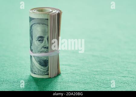 Gros plan sur le rouleau de cent billets de dollars américains Banque D'Images