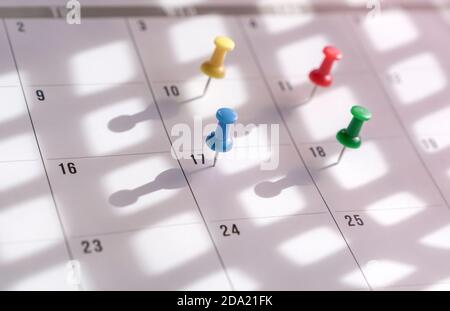 Épingles à molette sur le calendrier. Concept pour l'horaire occupé. Banque D'Images