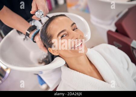 Bain d'eau pour les cheveux de femme souriante agréable Banque D'Images