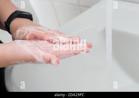 Mains savonnantes sur l'évier dans la salle de bains.mains d'hygiène et de nettoyage. Banque D'Images