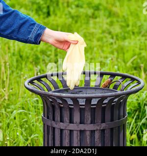 L'homme jette un gant médical dans une poubelle, gros plan Banque D'Images
