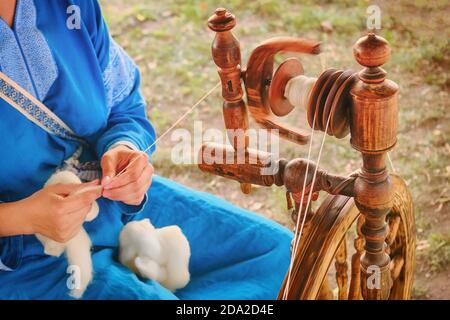 Distaff crée un filetage à partir d'une broche. Volant manuel à l'extérieur, style de vie. Banque D'Images