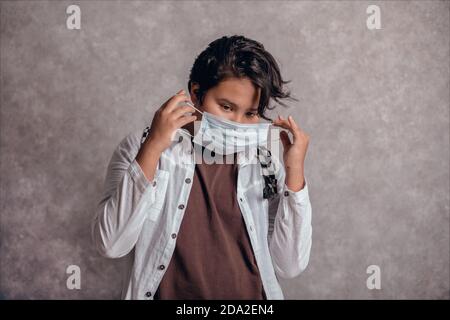 Adolescent avec masque de visage de retour à l'école après la quarantaine et le verrouillage Covid-19. Banque D'Images