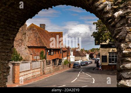 Royaume-Uni, Angleterre, East Sussex, Pevensey, Castle Road et Old Mint House à travers l'arche dans le mur romain Banque D'Images