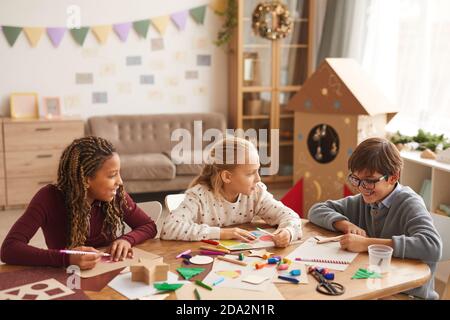 Groupe multi-ethnique d'enfants dessinant des images ensemble tout en appréciant l'art et l'artisanat, l'espace de copie Banque D'Images