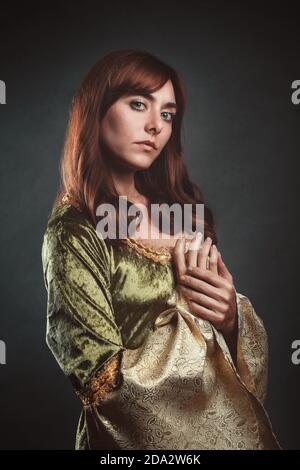 Belle femme en robe médiévale verte. Portrait de studio Banque D'Images