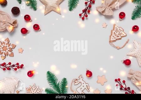 Cadre de Noël zéro déchet avec des décorations en verre, en textile et en bois, des cônes de pin, des sacs présents sur fond blanc witg lumières. Vue de dessus de la pose à plat Banque D'Images