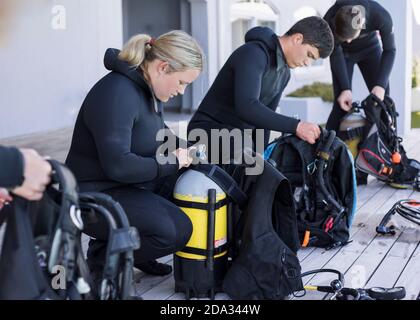 Un groupe de plongeurs se dressant et vérifiant leur équipement. Banque D'Images