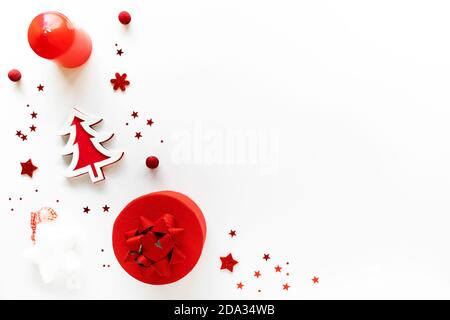 Composition artistique de Noël avec décor rouge, boîte cadeau et bougie blanche. Chritmas Eve, noël, concept cadeau. Vue de dessus de la pose à plat Banque D'Images