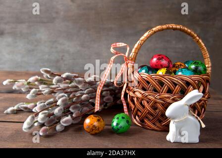 Panier en osier avec œufs de Pâques et bouquet de brindilles de saule Banque D'Images